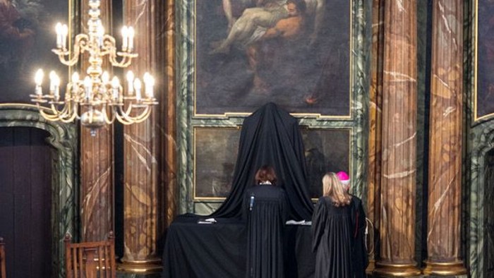 In prunkvollem Raum mit Gemälde und Kronleuchter.