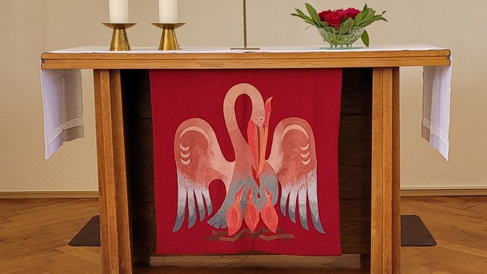 Ein Altar mit Kerzen, Kreuz und farbenfrohem Fenster