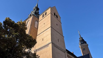 Zwei hohe Kirchtürme vor blauem Himmel