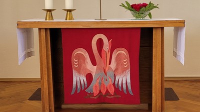 Ein Altar mit Kerzen, Kreuz und farbenfrohem Fenster