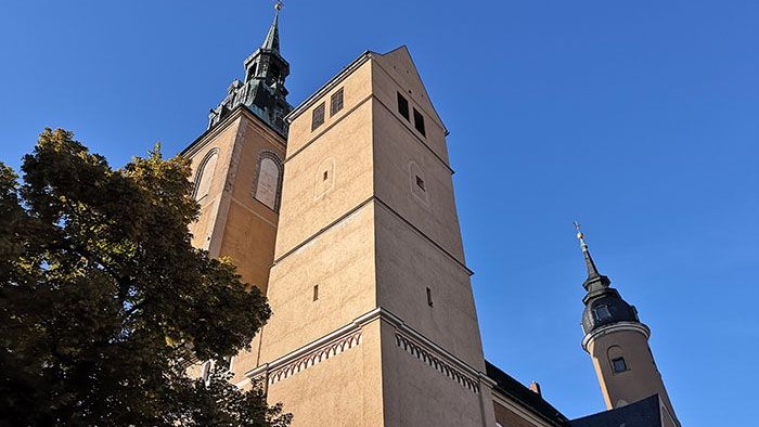 Zwei hohe Kirchtürme vor blauem Himmel