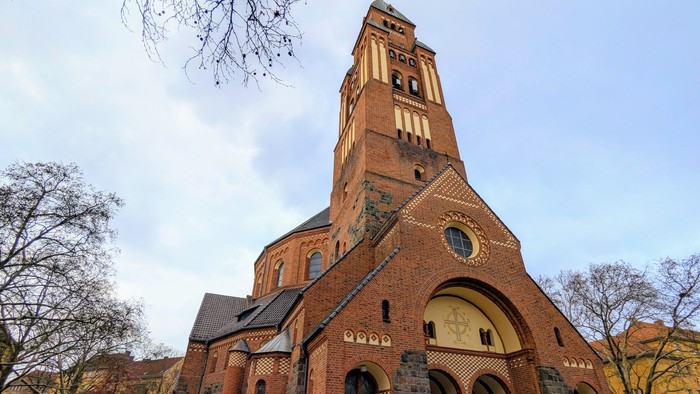 Große Ziegelkirche mit hohem Turm und Rundbogenfenster