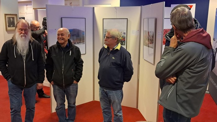 Eine Gruppe älterer Männer besichtigt eine Kunstausstellung.