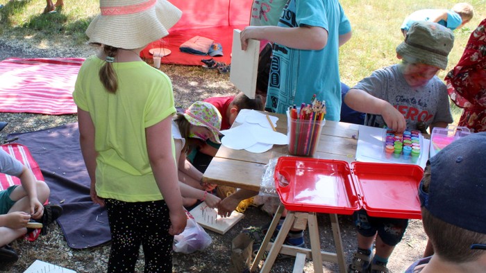 Kinder malen bei einem Fest im Freien