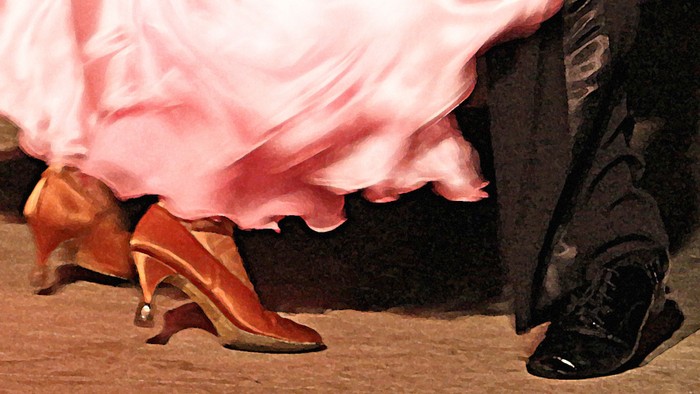 Ein Paar Tanzschuhe, eine rosa Schleppe und schwarze Lederschuhe auf einem Holzboden