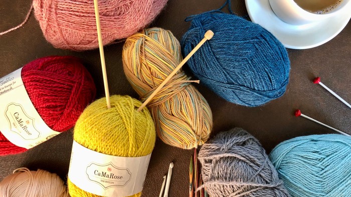 Bolle af garn i forskellige farver med strå og knipling.