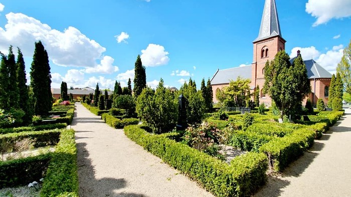 En smuk kirke med en have og træer