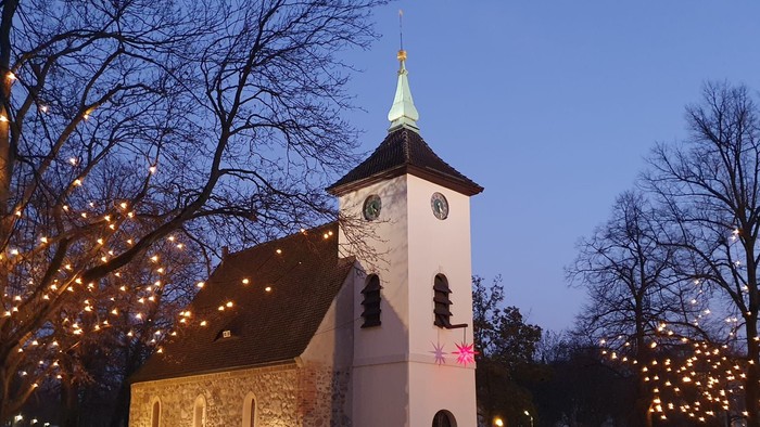 Kirche, die nachts mit Lichterketten an den Bäumen beleuchtet ist