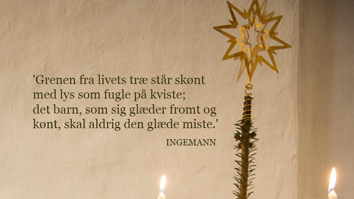 En hånd tænder lys på et pyntet juletræ med et poetisk citat på dansk.