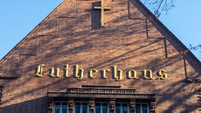 Das Bild zeigt das Lutherhaus mit einem Kreuz und einem Fenster.