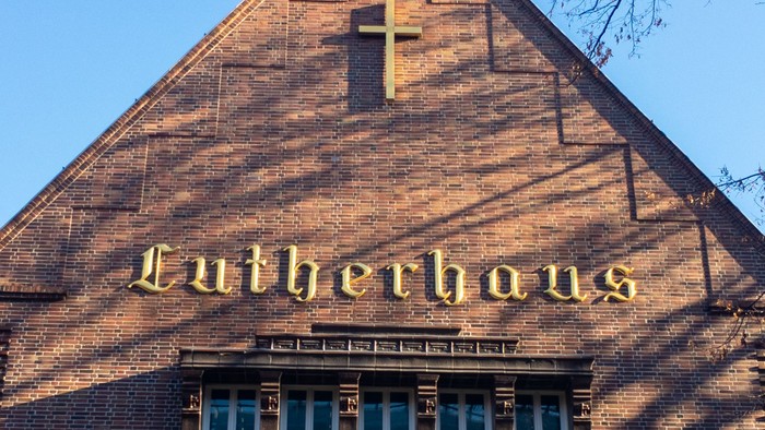 Das Bild zeigt das Lutherhaus mit einem Kreuz und einem Fenster.
