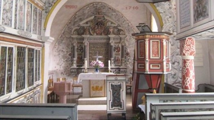 Die Kirche hat einen schönen Altar und hohe Decken.