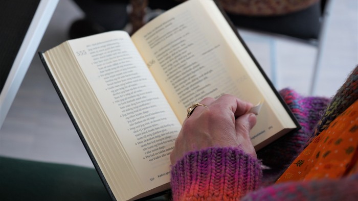 En person læser et bog med en farverig strømpe.