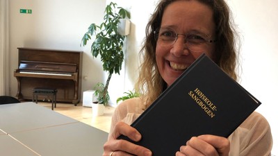 Kvinde viser med glæde sin eksamen i piano.