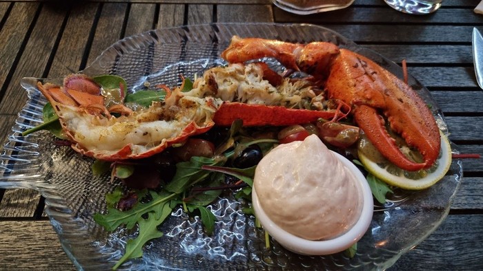 Teller mit Hummer in Sauce und Zitronenspalte