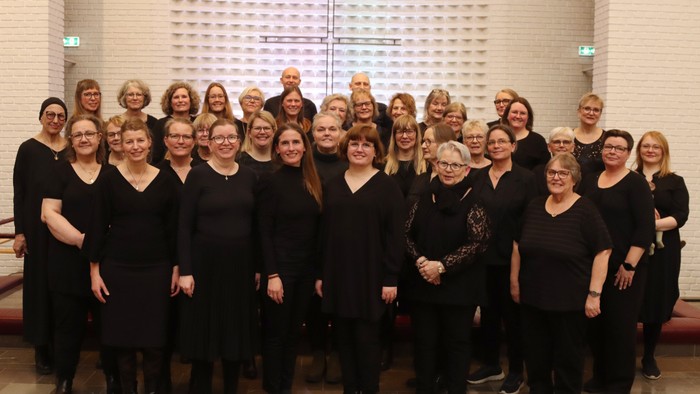 En gruppe kvinder i mørke klæder samlet til et billede