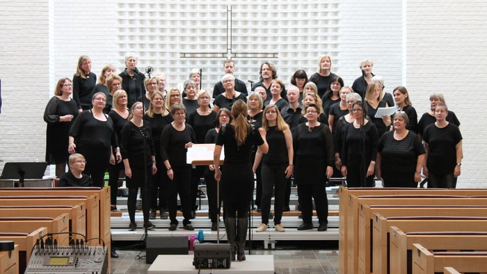 En stor kor, der synger i en kirke.