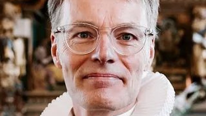 Kvinde med briller og hvid krave.