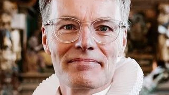 Kvinde med briller og hvid krave.