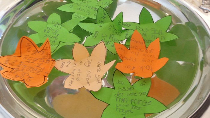 Børn laver blader af papir og skriver på dem