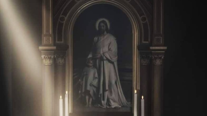 Gotisk alter med religiøs kunst, lys og en døbefont oplyst af varmt lys.