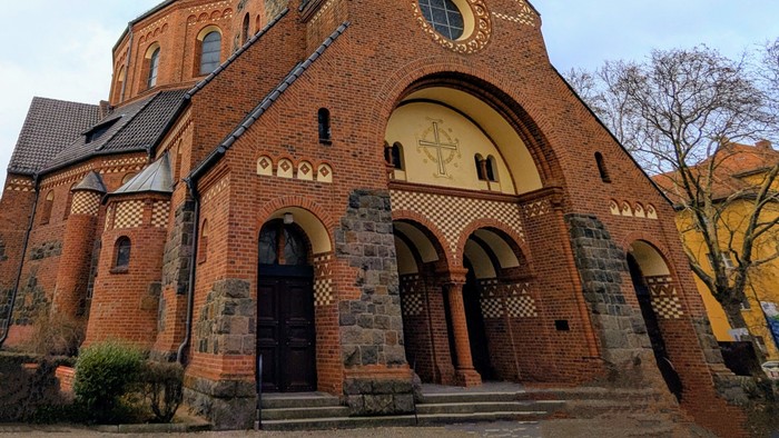 Große Ziegelkirche mit hohem Turm und Rundbogenfenster