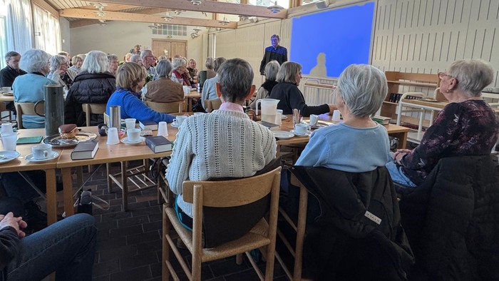 Forsamling af mennesker lytter til foredragsholder