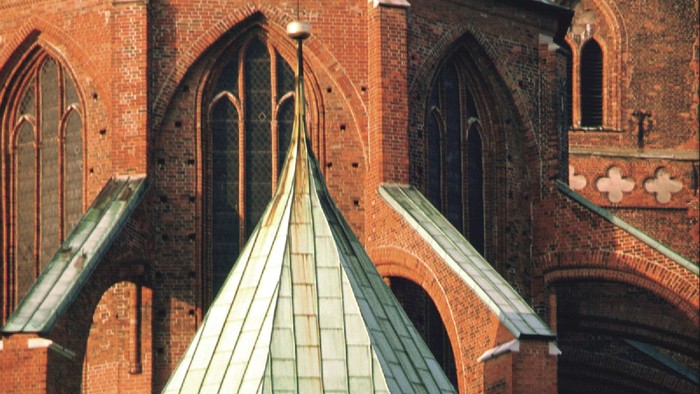 Das Bild zeigt eine gotische Kirche mit grünen Kupferdächern.