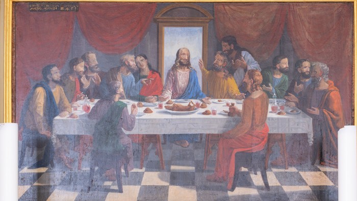 Billedet viser et alter med en maleri af den sidste nattid og to lysstake.