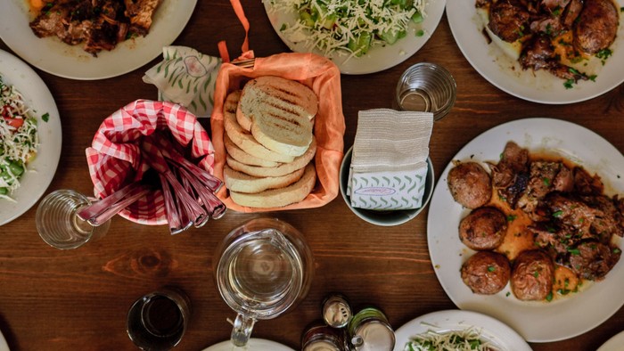 Verschiedene Gerichte und Salate auf einem Tisch mit Gläsern und Besteck