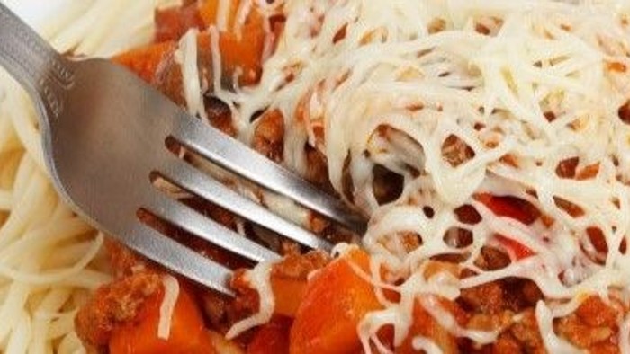 En gabel i en ret med pasta, tomatsoace og ost.