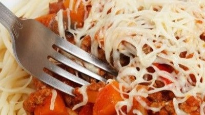 En gabel i en ret med pasta, tomatsoace og ost.