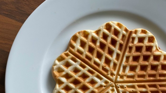 Das Bild zeigt einen Teller mit einer frischen Waffel
