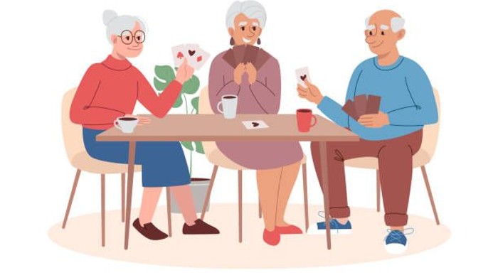 Vier ältere Menschen sitzen an einem Tisch und trinken Kaffee.