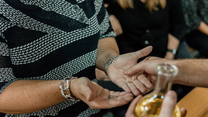 A person receives henna tattoo on their hand.