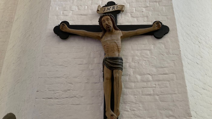 Ein Kruzifix an einer weißen Ziegelwand