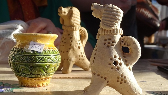 Handgefertigte Keramik-Hundefiguren und eine dekorative Vase auf einem Tisch ausgestellt.