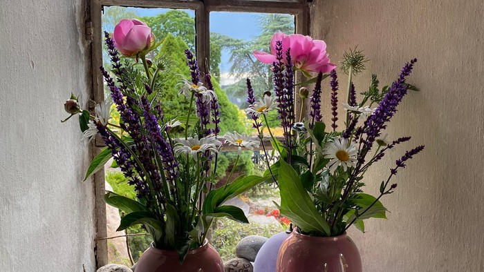To dige på vinduesbank med blomsterarrangementer