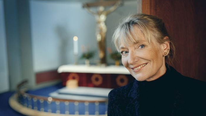 Kvinde i kirke med alter og krucifix.