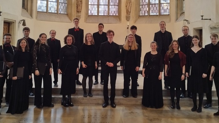 Eine Chor-Gruppe, die sich formell in einer eleganten historischen Kirche oder Kathedrale aufstellt.