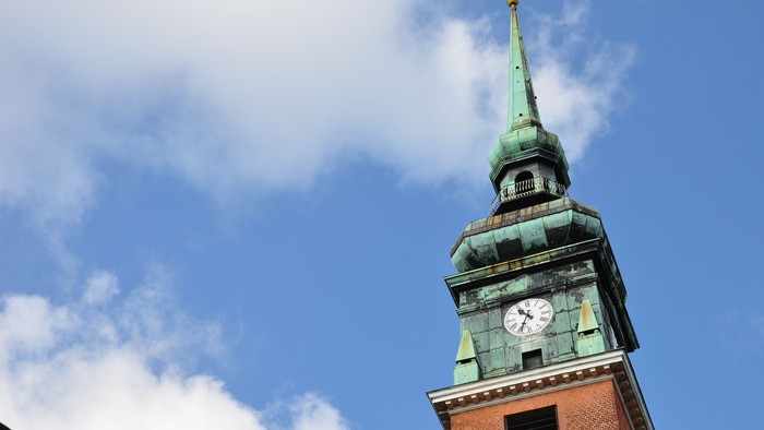 Der Kirchturm ragt hoch in den klaren blauen Himmel