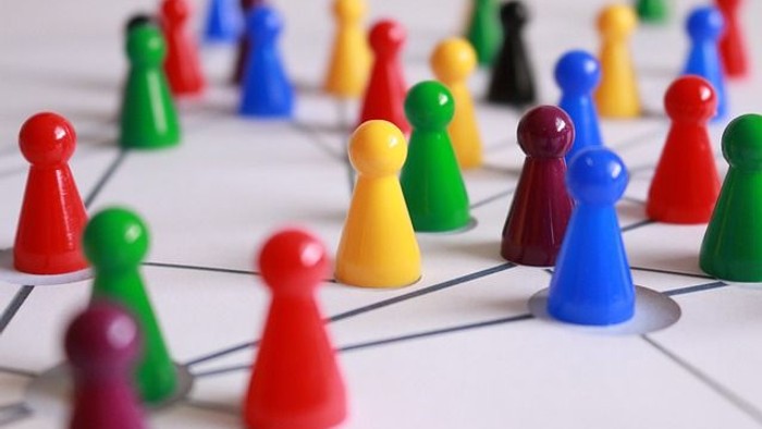 Bunte Plastikfiguren, die auf einem Raster-Spielbrett angeordnet sind.