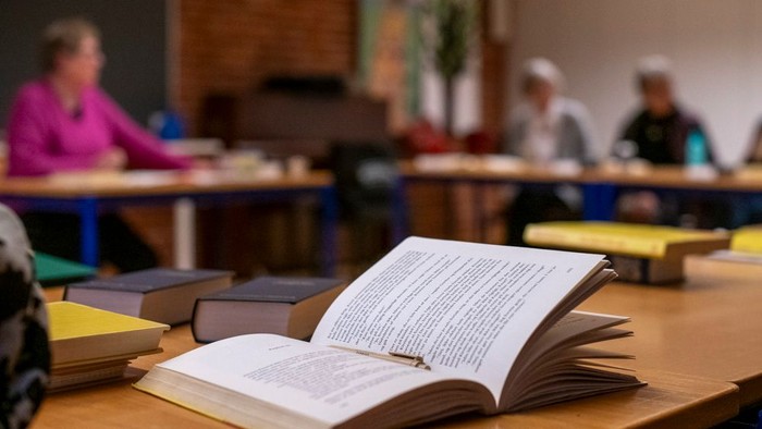 En åben bog på bordet i en biblioteksafdeling.