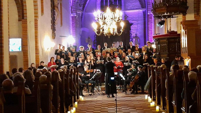 En kirke med en stor kor og orkester, lysekerler foran.