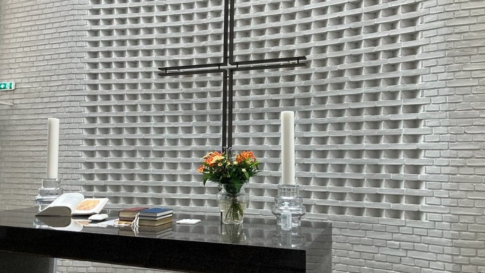 Alter med kors og blomster i kirke