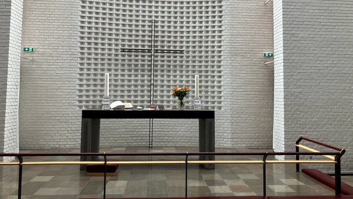 Moderne interiør med mønstret væg, glasbord og røde stole