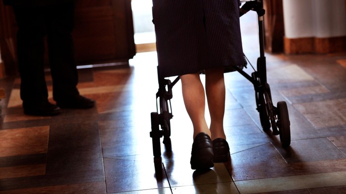 En person med walker går på gulv.