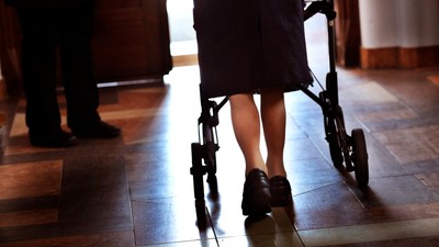 En person med walker går på gulv.