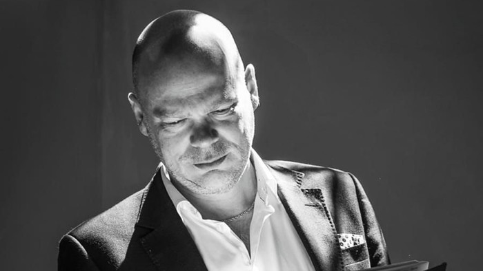 Mand i formel klædning læser fra en bog