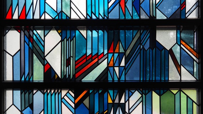 Buntes Buntglasfenster mit geometrischen Mustern und abstrakten Formen
